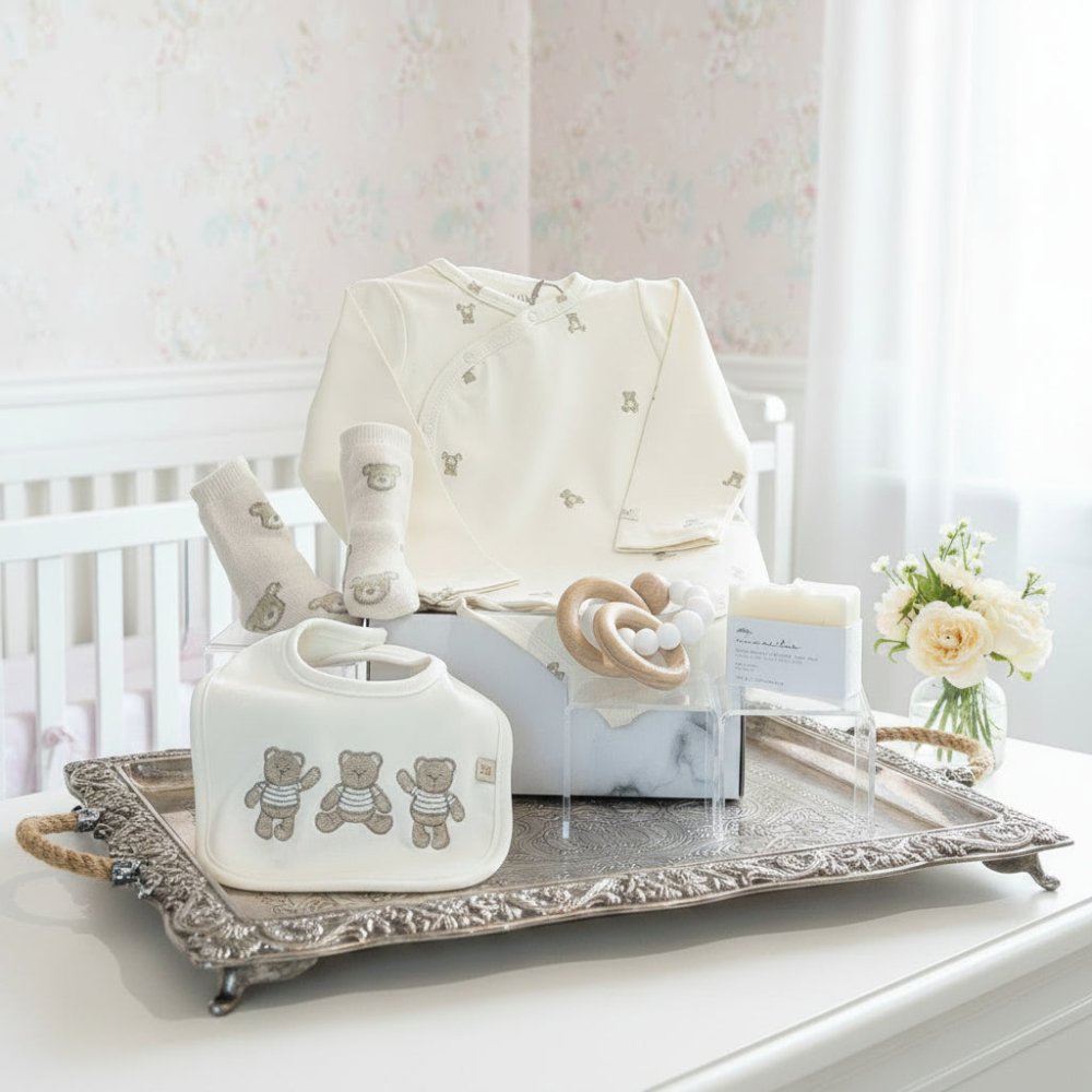 coffret cadeau avec combinaison bébé, bavette, chaussons, anneau de dentition et savon pour bébé